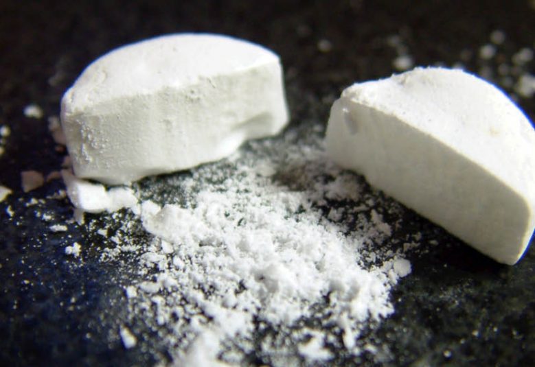 close up of a pill that is cut in two pieces