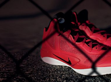 Red running shoes behind a wire fence