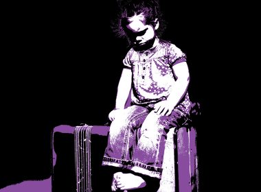 Child sits on a suitcase