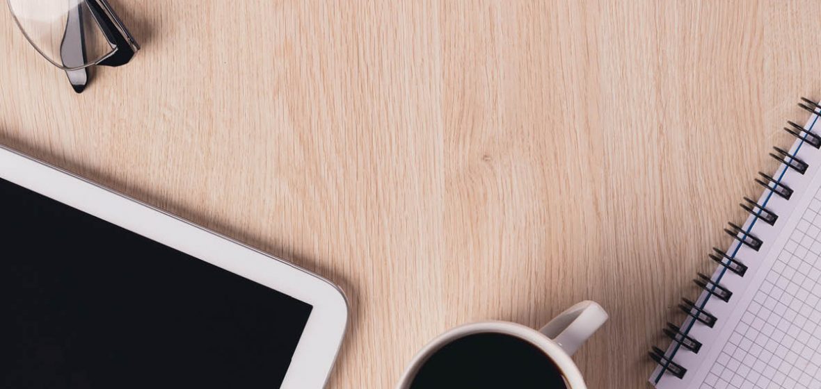 Office desk with coffee and iPad.