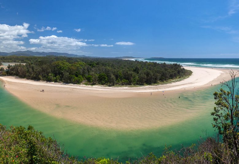 Small sand-bar island connected to mainland by bridge