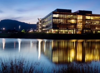 View of several office buildings across a lake, at dusk