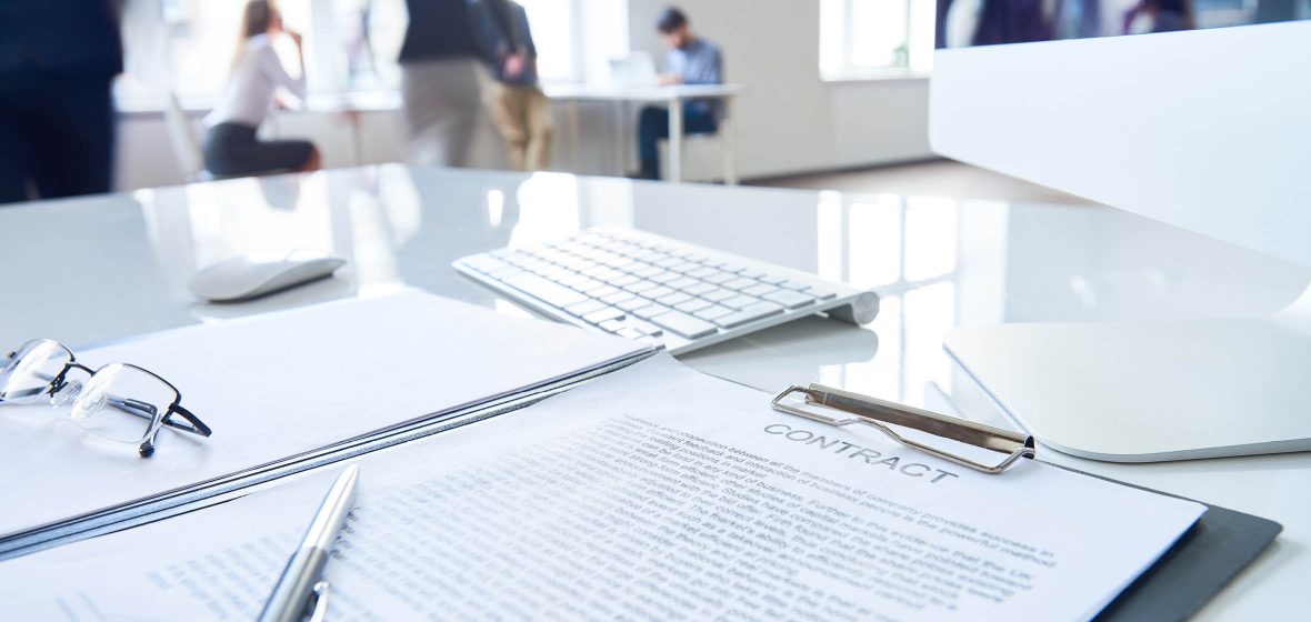 Close up of contract document on a desk with pen awaiting signature