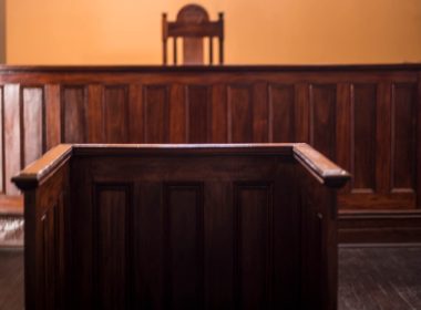 An empty witness box faces an empty court bench