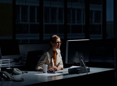 woman using a computer in a dark office