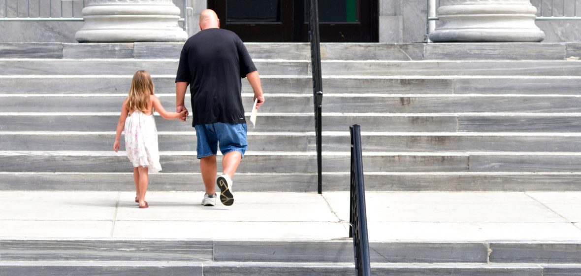Man and child walking up courthouse steps