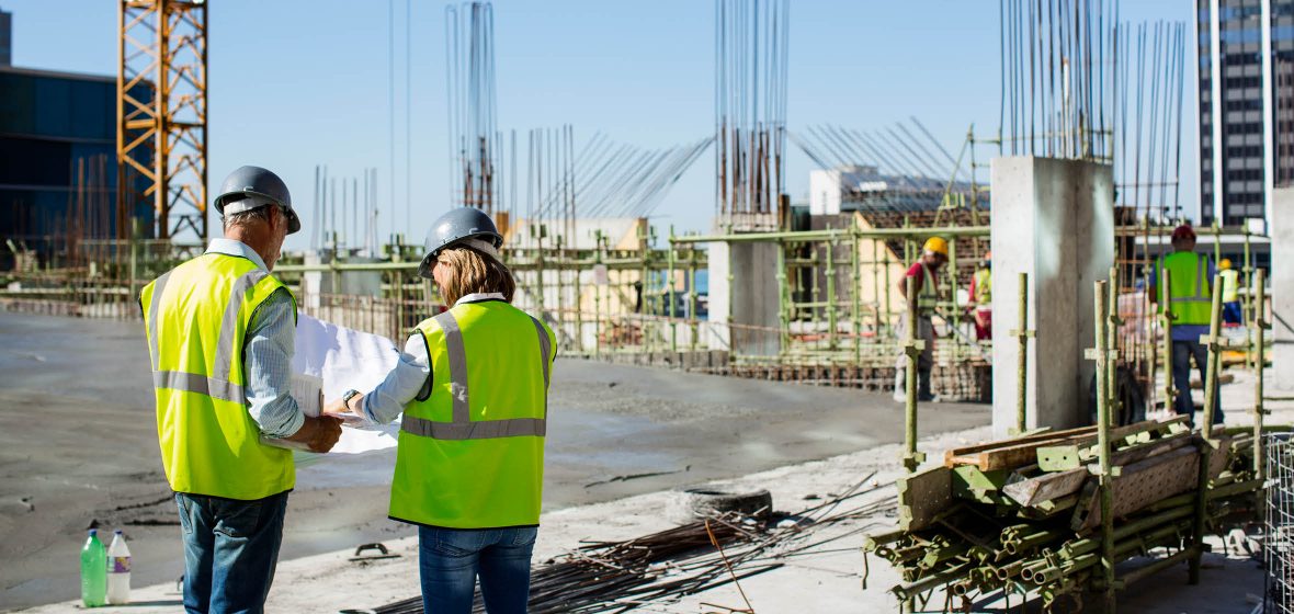 Construction workers consult plans on a building site