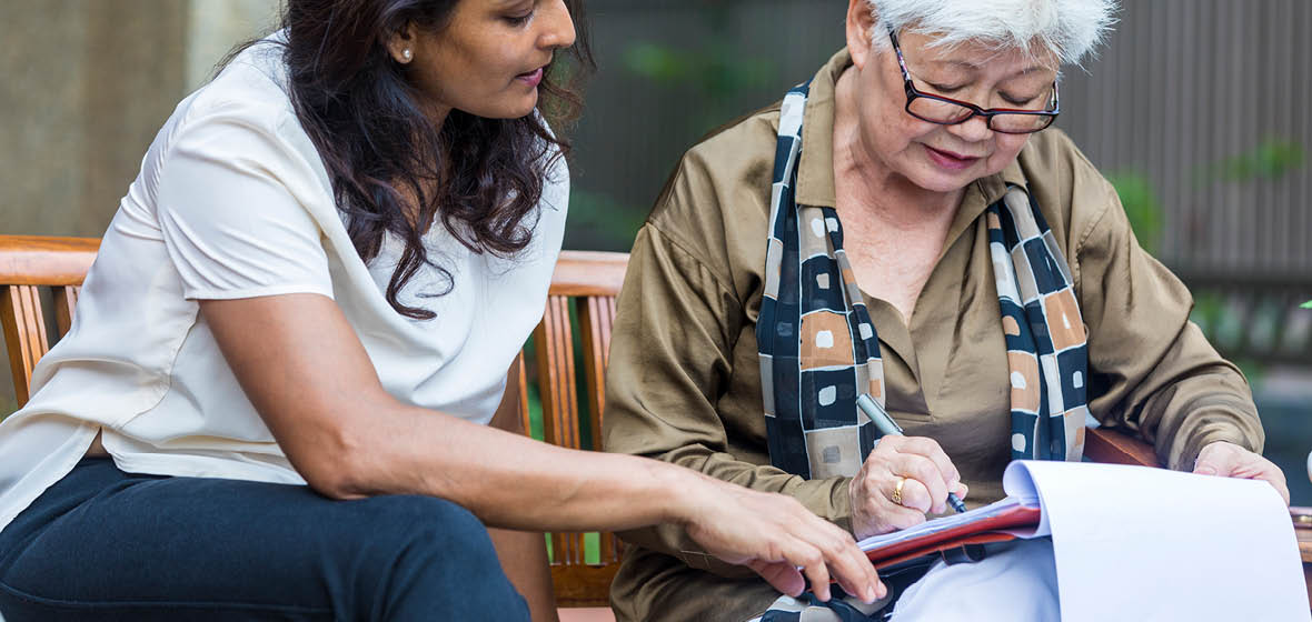 Solicitor reviews document with older female client