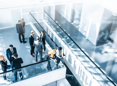 Colleagues networking in an open plan area of an office