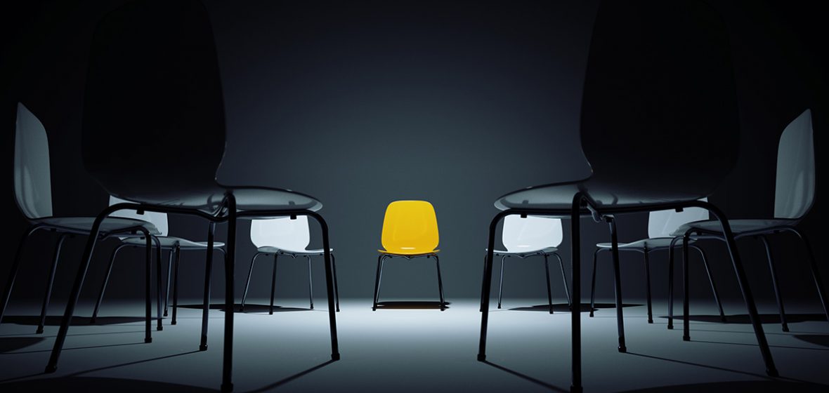 Circle of white chairs. One is yellow.