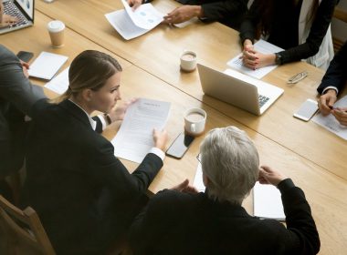 team of solicitors sitting at a table reviewing documents