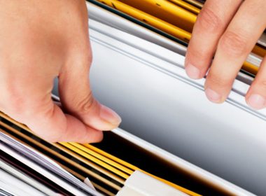 woman's hands going through filing cabinet