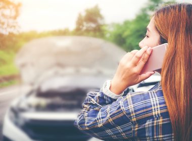Young Woman calling for assistance with his car broken down by the roadside