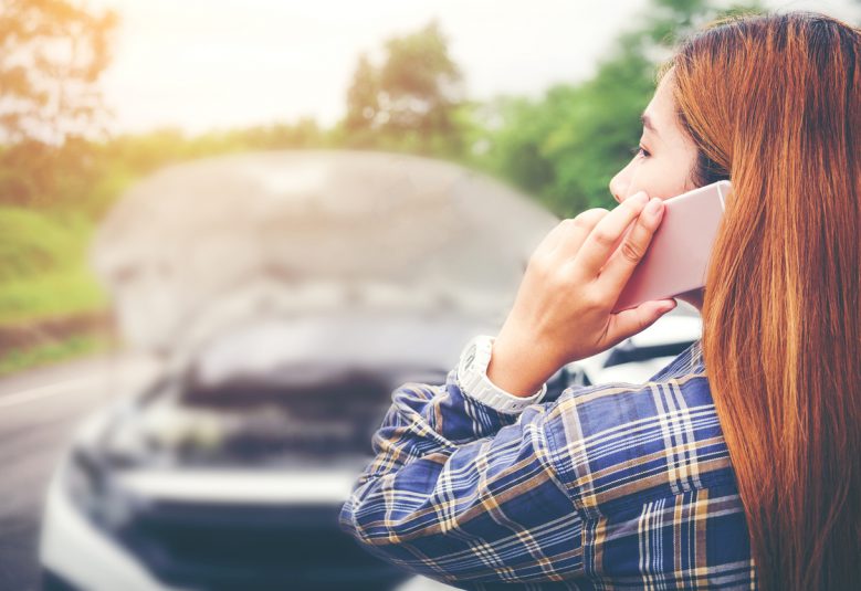 Young Woman calling for assistance with his car broken down by the roadside