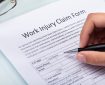 Close-up Of A Woman's Hand Filling Work Injury Claim Form