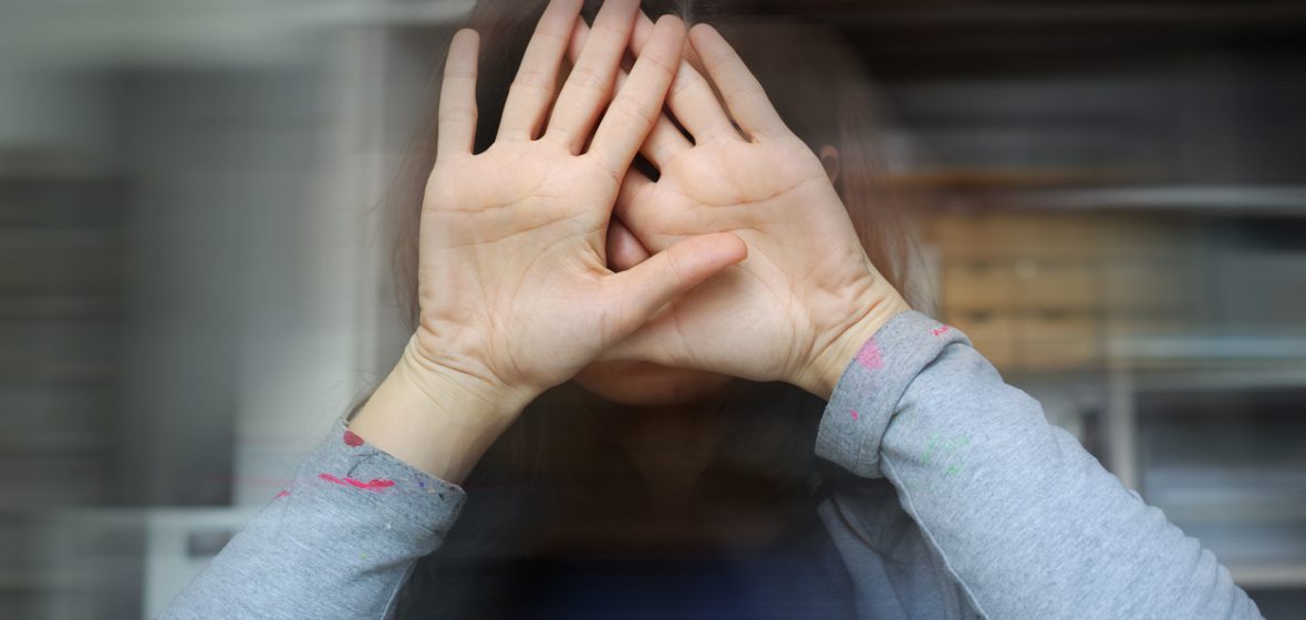 Woman covers her face with her hands
