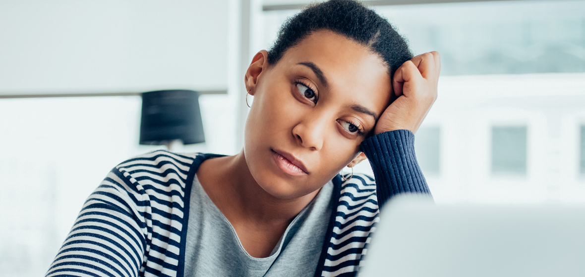 Tired woman looks at her computer