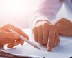Two men review a document