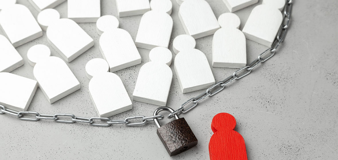 Human shaped puzzle pieces encircled by a chain and padlock.