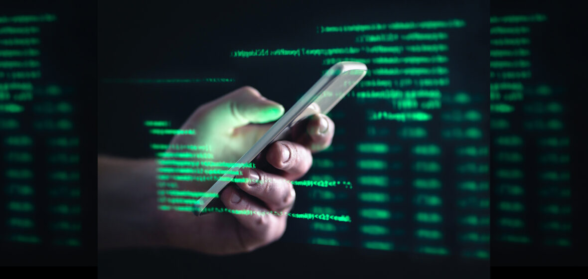 photo of hand on phone in front of data to show consumer scams
