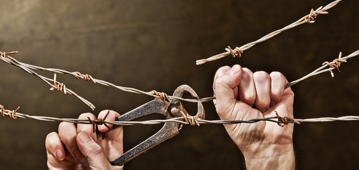 photo of hands cutting barbed wire to symbolise end to indefinite detention