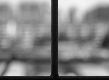 photo of barred window with grey scenery outside to depict poor mental health of prisoners