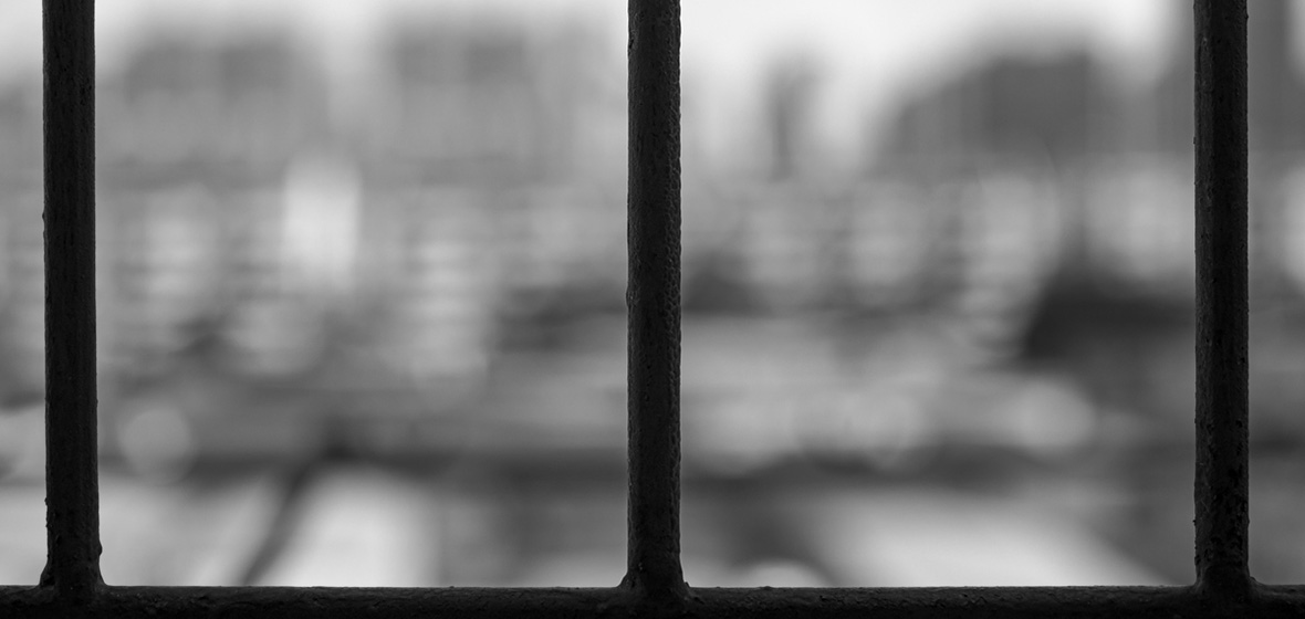 photo of barred window with grey scenery outside to depict poor mental health of prisoners